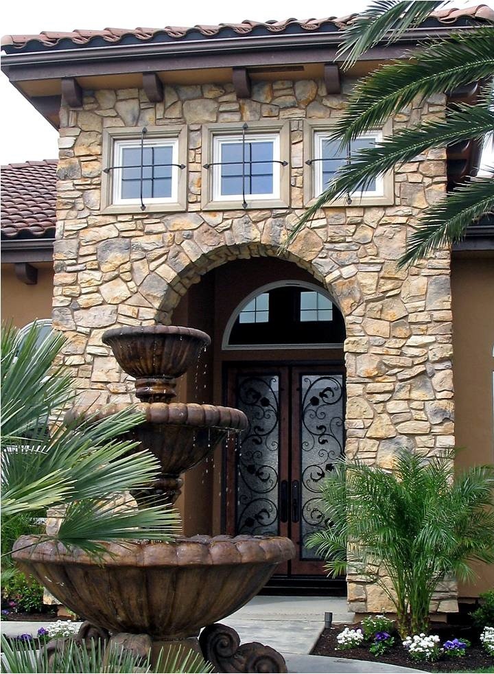 Стильный дизайн: большой, двухэтажный, коричневый дом в средиземноморском стиле с облицовкой из камня - последний тренд