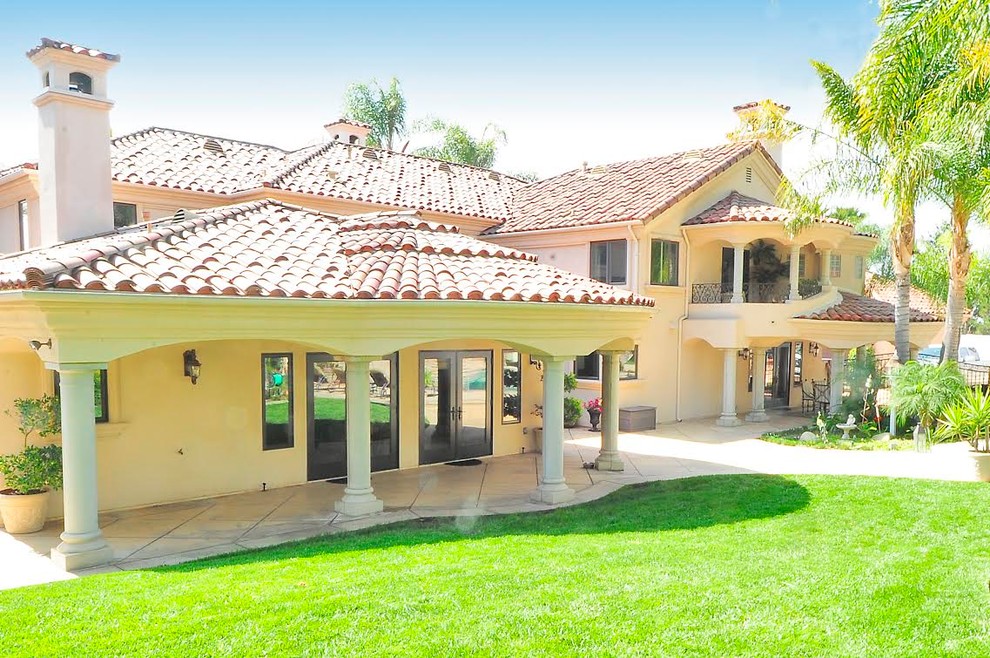 Foto de fachada de casa beige mediterránea extra grande de dos plantas con revestimiento de estuco, tejado a dos aguas y tejado de teja de barro