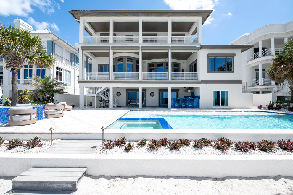 Geräumiges, Dreistöckiges Maritimes Einfamilienhaus mit Putzfassade, beiger Fassadenfarbe, Ziegeldach und Flachdach in Tampa