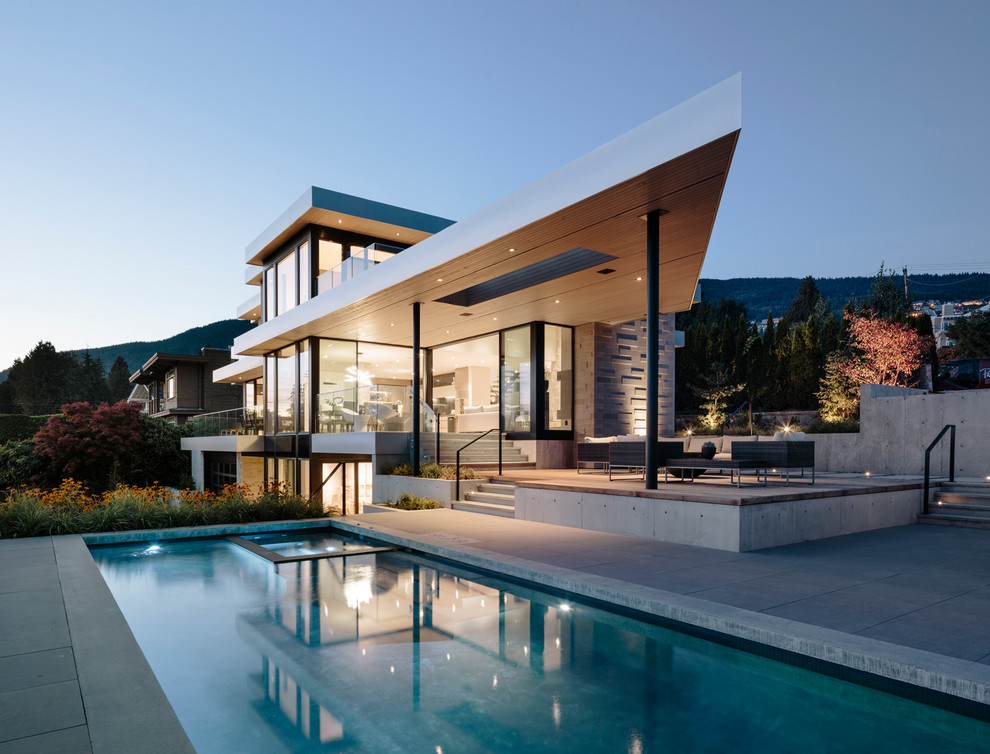 Großes, Dreistöckiges Modernes Einfamilienhaus mit Steinfassade, beiger Fassadenfarbe und Flachdach in Vancouver