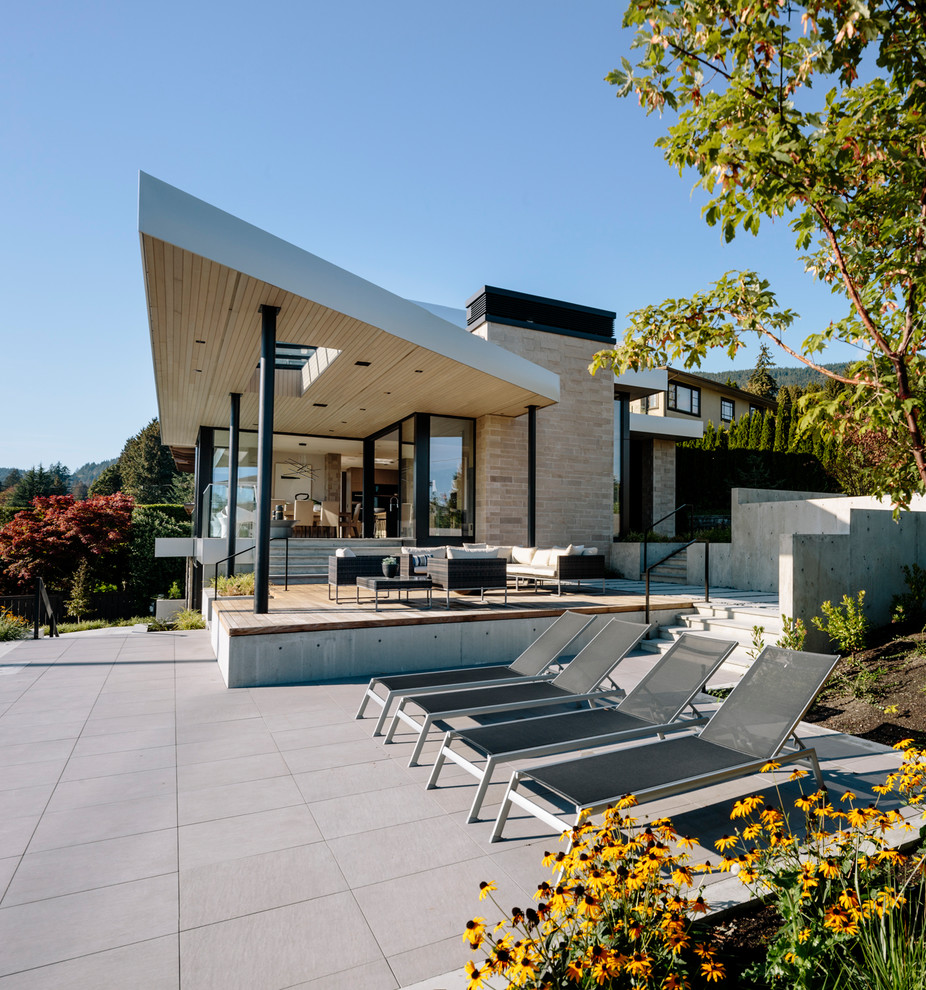 Inspiration pour une grande façade de maison beige design en pierre à deux étages et plus avec un toit plat.