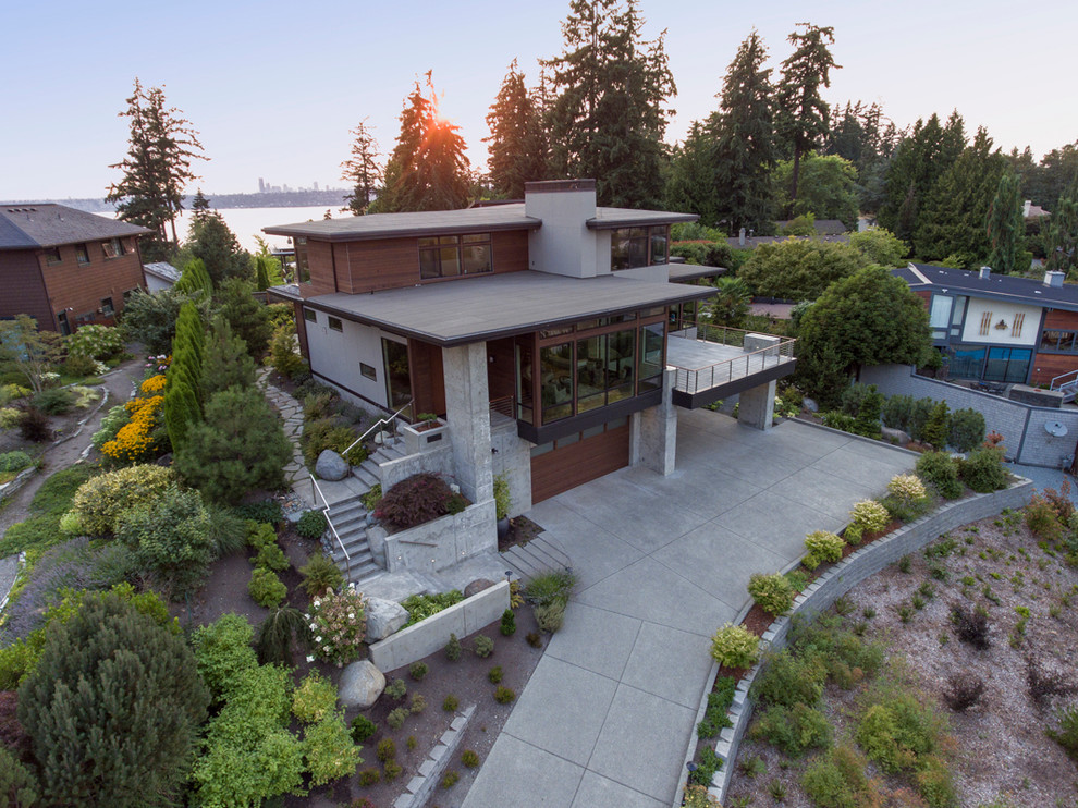 This is an example of a gey and large modern concrete detached house in Seattle with three floors and a flat roof.