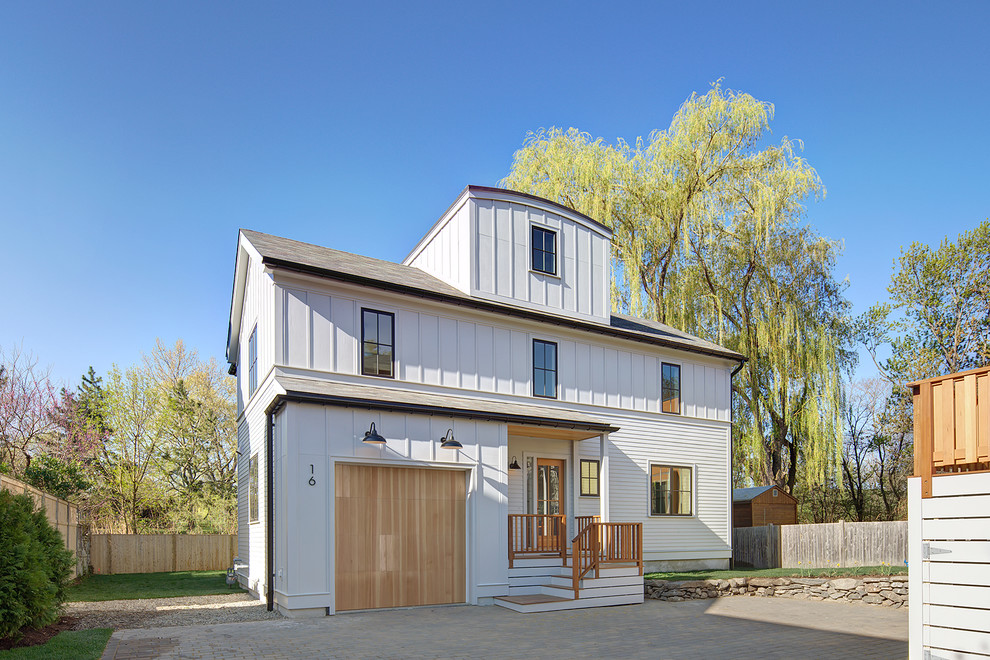 Réalisation d'une façade de maison blanche design en bois de taille moyenne et à un étage avec un toit à deux pans et un toit en shingle.