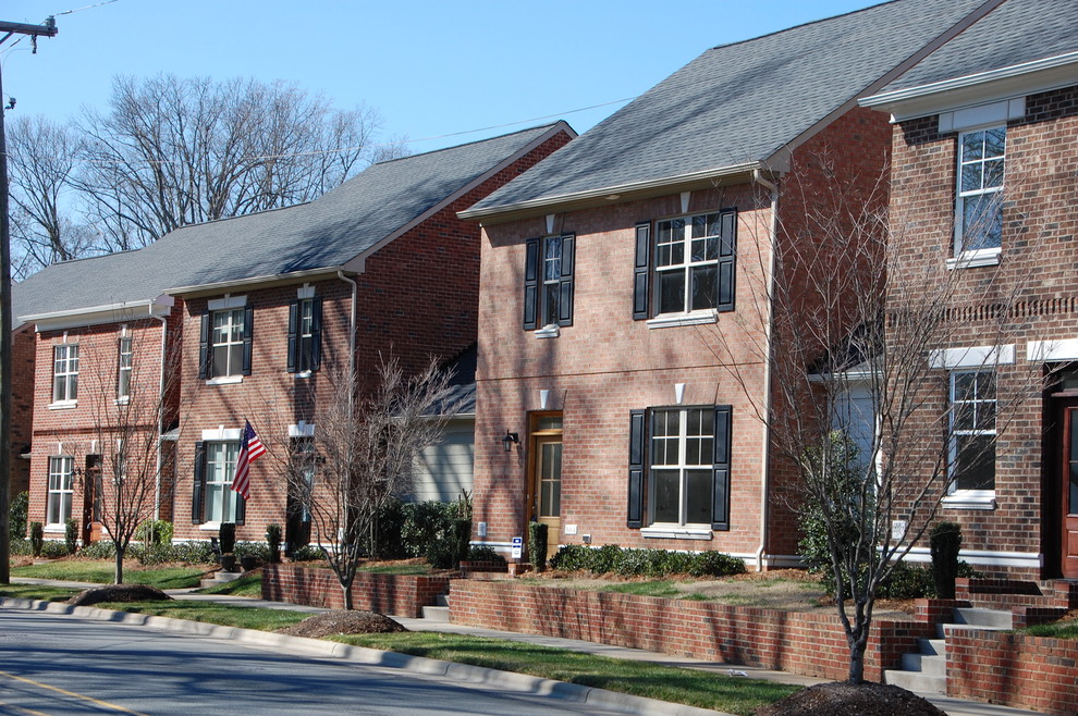 This is an example of a large and red classic two floor brick terraced house in Charlotte with a pitched roof and a shingle roof.