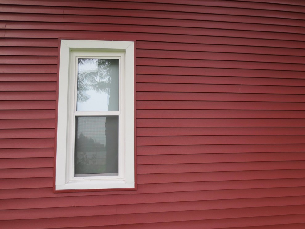 Mittelgroßes, Zweistöckiges Landhausstil Haus mit roter Fassadenfarbe, Satteldach und Schindeldach in Grand Rapids