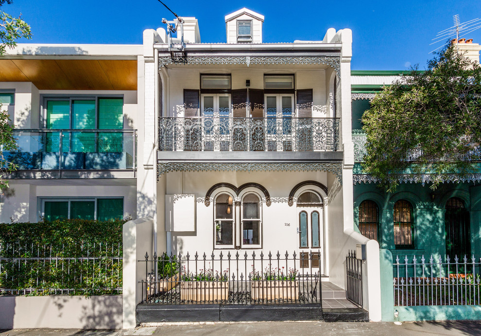 Cette image montre une façade de maison beige traditionnelle en béton à un étage.