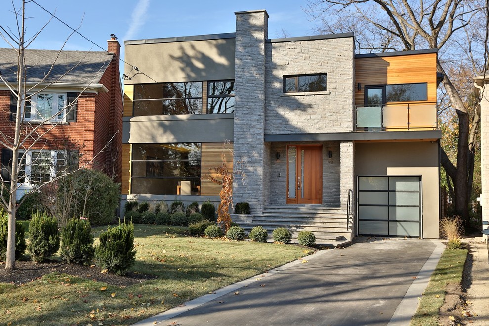 Inspiration pour une grande façade de maison multicolore design à un étage avec un revêtement mixte et un toit plat.