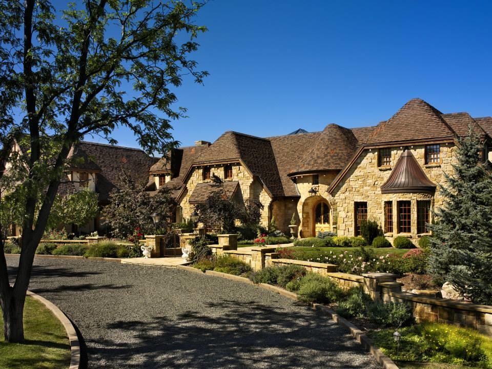Inspiration for a large mediterranean brown two-story stone house exterior remodel in Other with a hip roof and a shingle roof