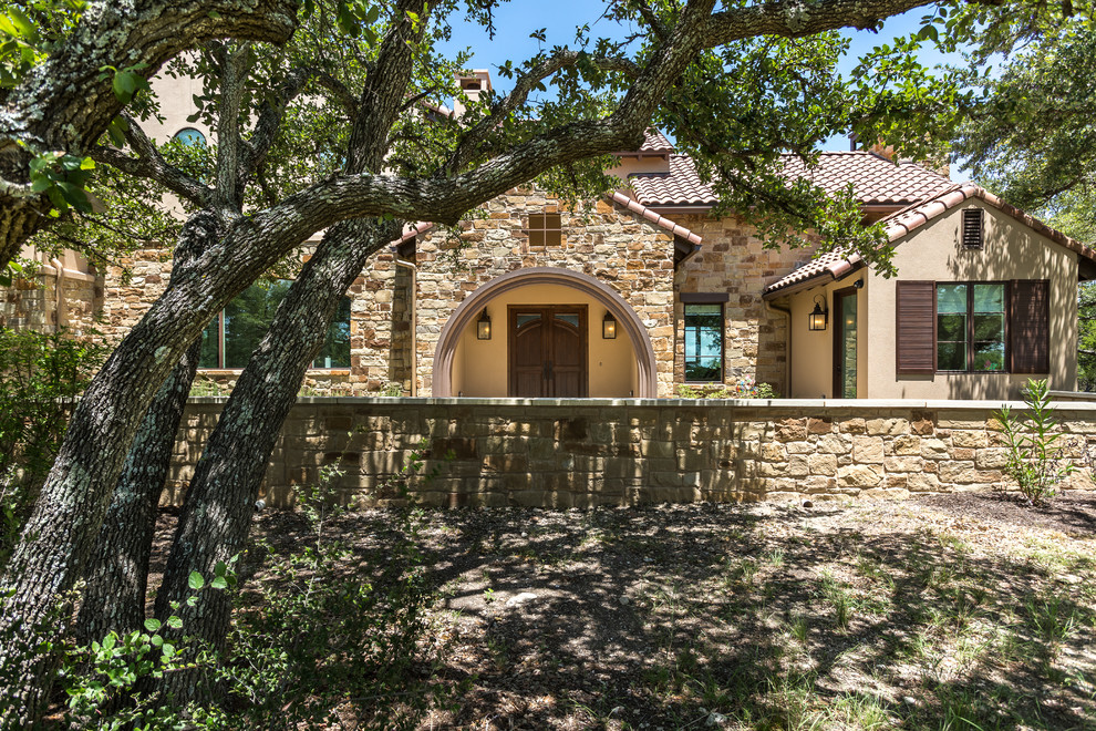 Example of a large southwest beige two-story mixed siding exterior home design in Austin with a tile roof
