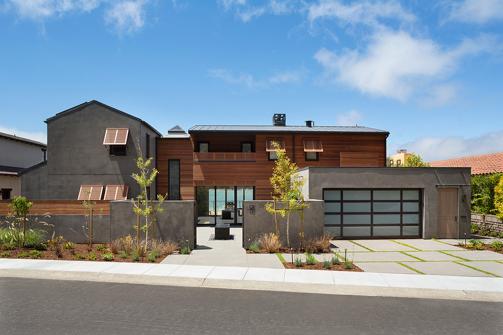 Cette photo montre une très grande façade de maison marron tendance à un étage avec un revêtement mixte et un toit à deux pans.