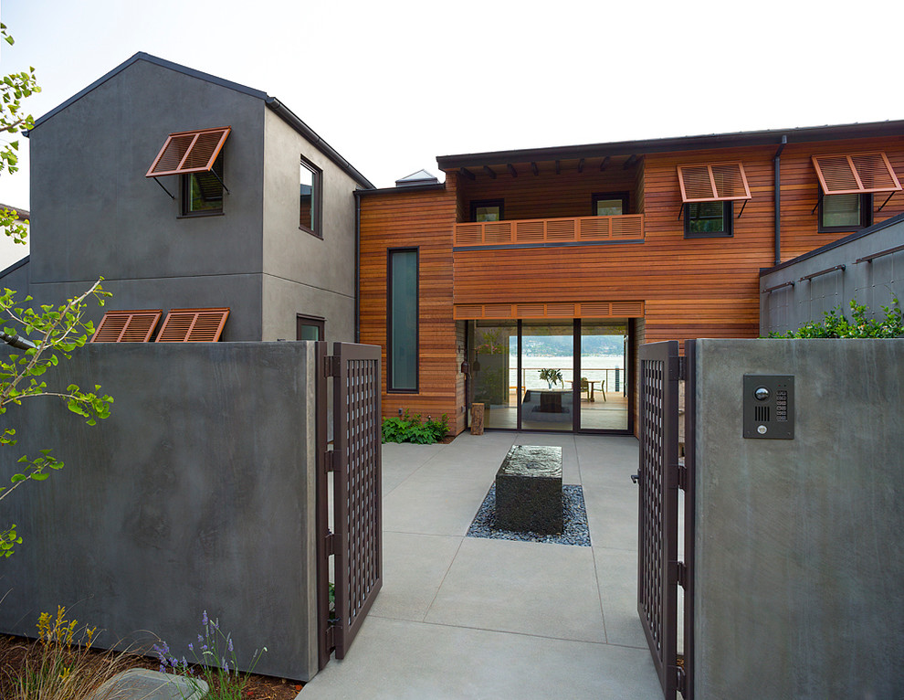 На фото: огромный, двухэтажный, коричневый дом в современном стиле с комбинированной облицовкой и двускатной крышей с