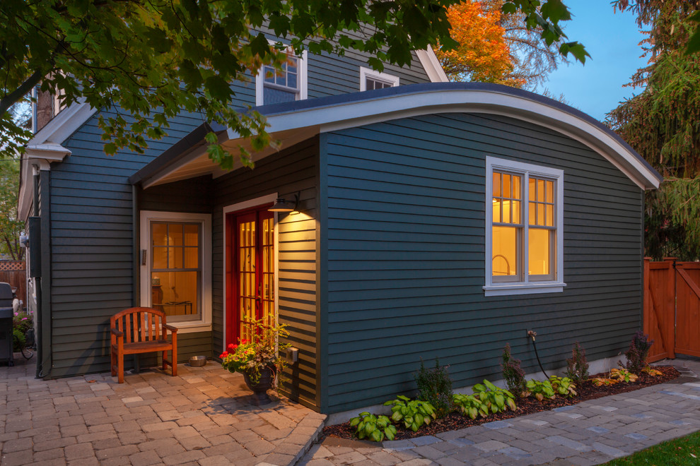 Modelo de fachada de casa verde escandinava de tamaño medio de una planta con revestimiento de madera y tejado de metal