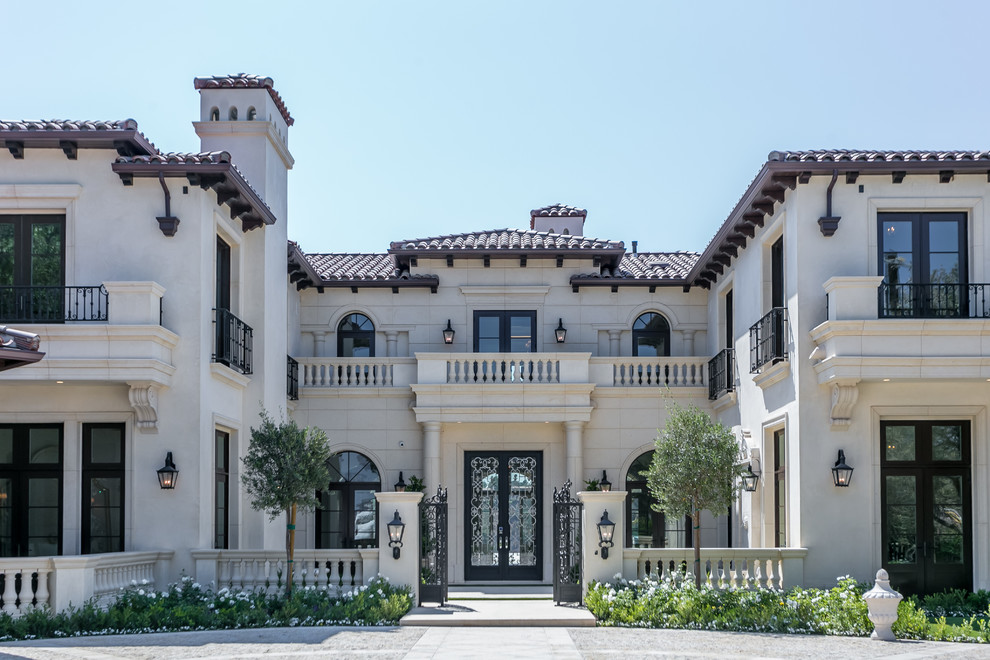 Großes, Zweistöckiges Mediterranes Haus mit Steinfassade, beiger Fassadenfarbe und Walmdach in Los Angeles