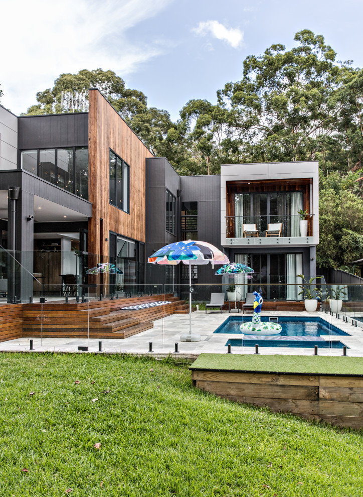 Geräumiges Modernes Haus mit schwarzer Fassadenfarbe, Flachdach und Blechdach in Wollongong