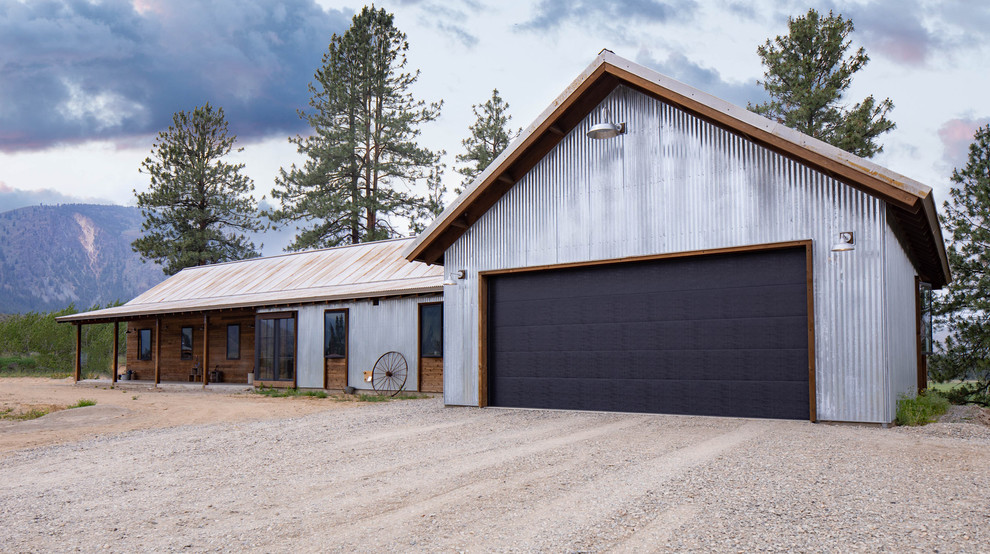 Foto på ett mellanstort industriellt grått hus, med allt i ett plan, metallfasad, sadeltak och tak i metall
