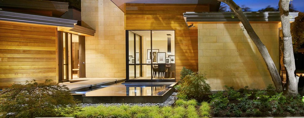 На фото: огромный, одноэтажный, коричневый частный загородный дом в стиле модернизм с комбинированной облицовкой, плоской крышей и крышей из смешанных материалов с
