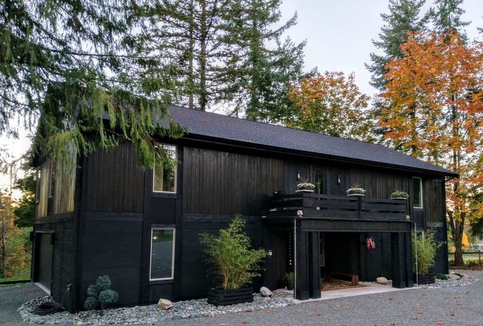 Ejemplo de fachada de casa negra minimalista de tamaño medio de dos plantas con revestimiento de madera, tejado a dos aguas y tejado de teja de madera