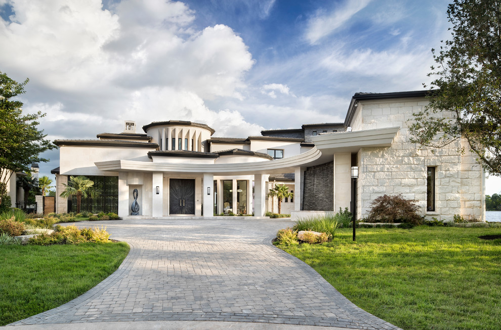 Diseño de fachada de casa beige actual extra grande de dos plantas con revestimiento de piedra