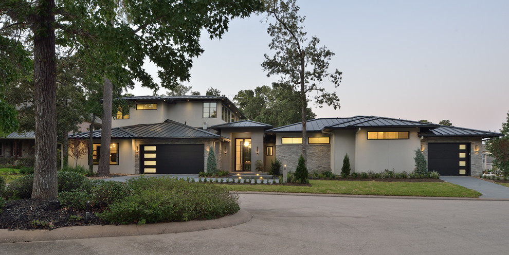 Zweistöckiges Modernes Einfamilienhaus mit Putzfassade, grauer Fassadenfarbe und Blechdach in Houston