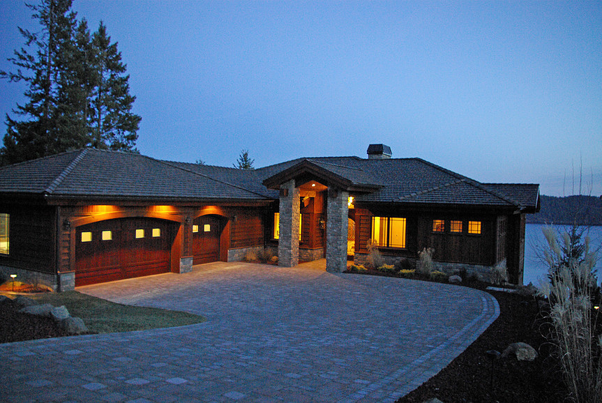 Réalisation d'une grande façade de maison grise chalet en bois à un étage avec un toit à deux pans.