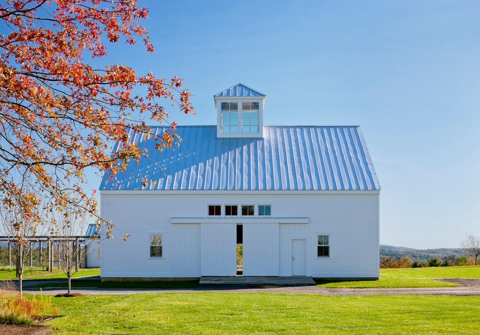 Esempio della facciata di una casa ampia bianca country a due piani con rivestimento in legno e tetto a capanna
