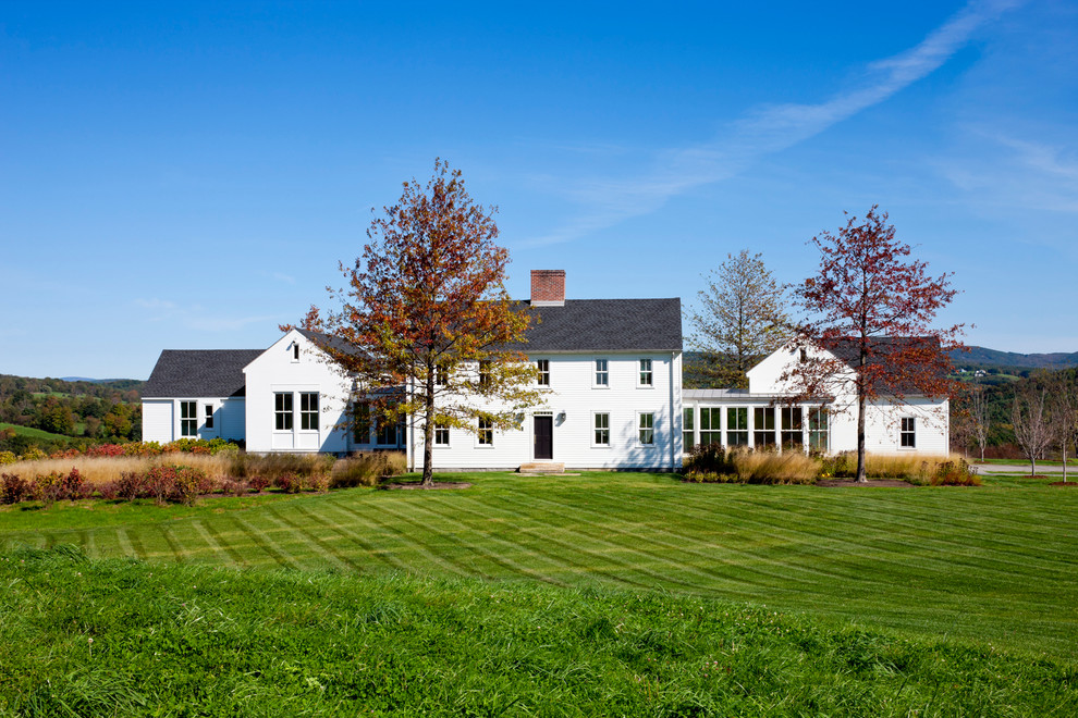 Ejemplo de fachada blanca de estilo de casa de campo extra grande de dos plantas con revestimiento de madera y tejado a dos aguas