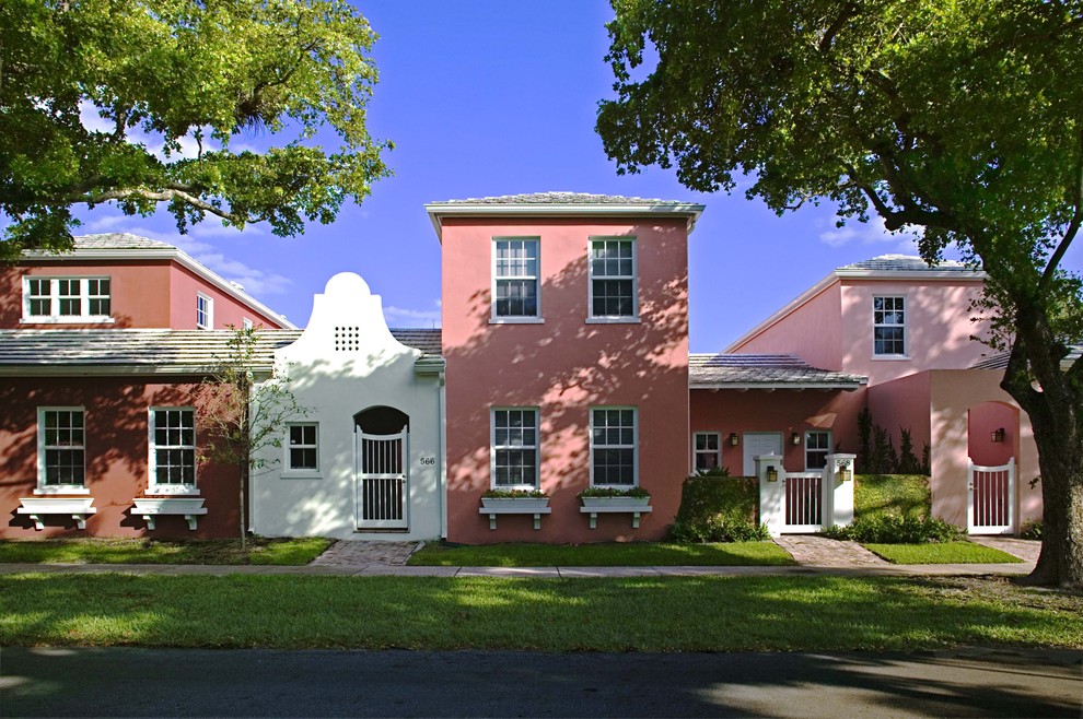 マイアミにあるトロピカルスタイルのおしゃれな家の外観 (ピンクの外壁) の写真