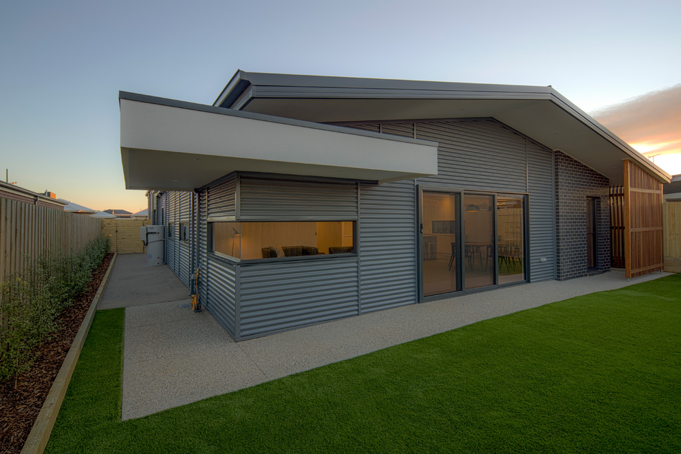 Design ideas for a medium sized and gey contemporary bungalow house exterior in Melbourne with concrete fibreboard cladding and a lean-to roof.