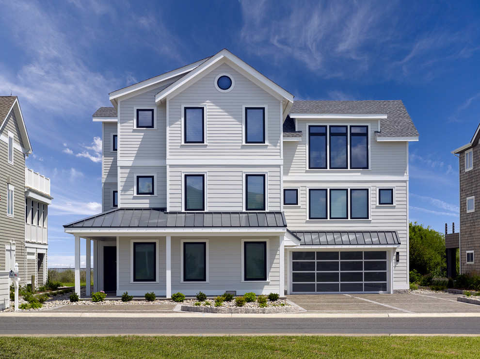 Large beach style white three-story exterior home photo in Wilmington with a mixed material roof