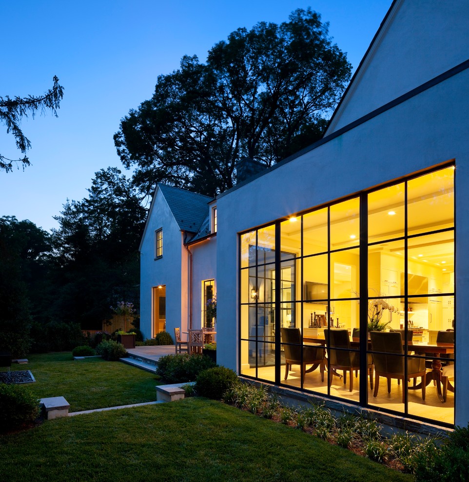 На фото: белый дом в стиле неоклассика (современная классика) с двускатной крышей