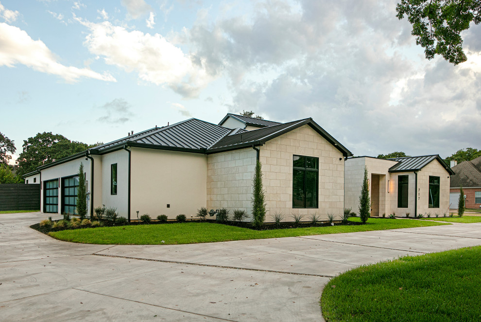 Photo of a large and white contemporary bungalow house exterior in Dallas with stone cladding and a metal roof.