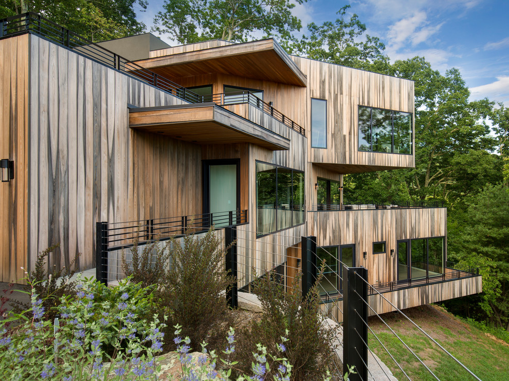 Idéer för ett modernt brunt trähus, med platt tak