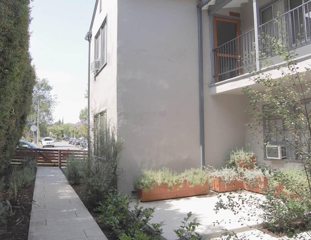 Kleines, Zweistöckiges Klassisches Wohnung mit Putzfassade, grauer Fassadenfarbe, Satteldach und Schindeldach in Los Angeles
