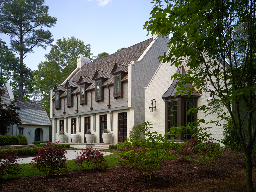 Großes, Zweistöckiges Einfamilienhaus mit Backsteinfassade, weißer Fassadenfarbe und Schindeldach in Charlotte