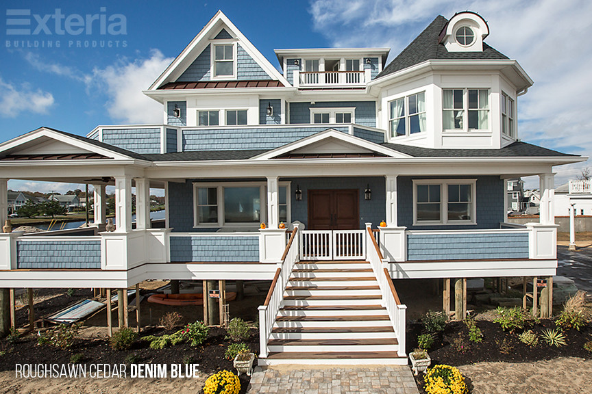 Idée de décoration pour une grande façade de maison bleue marine à deux étages et plus avec un revêtement mixte.