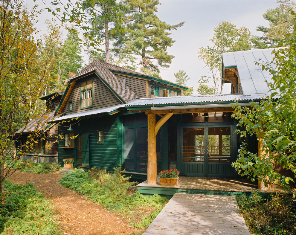 Exempel på ett stort rustikt grönt hus, med två våningar, sadeltak och tak i shingel