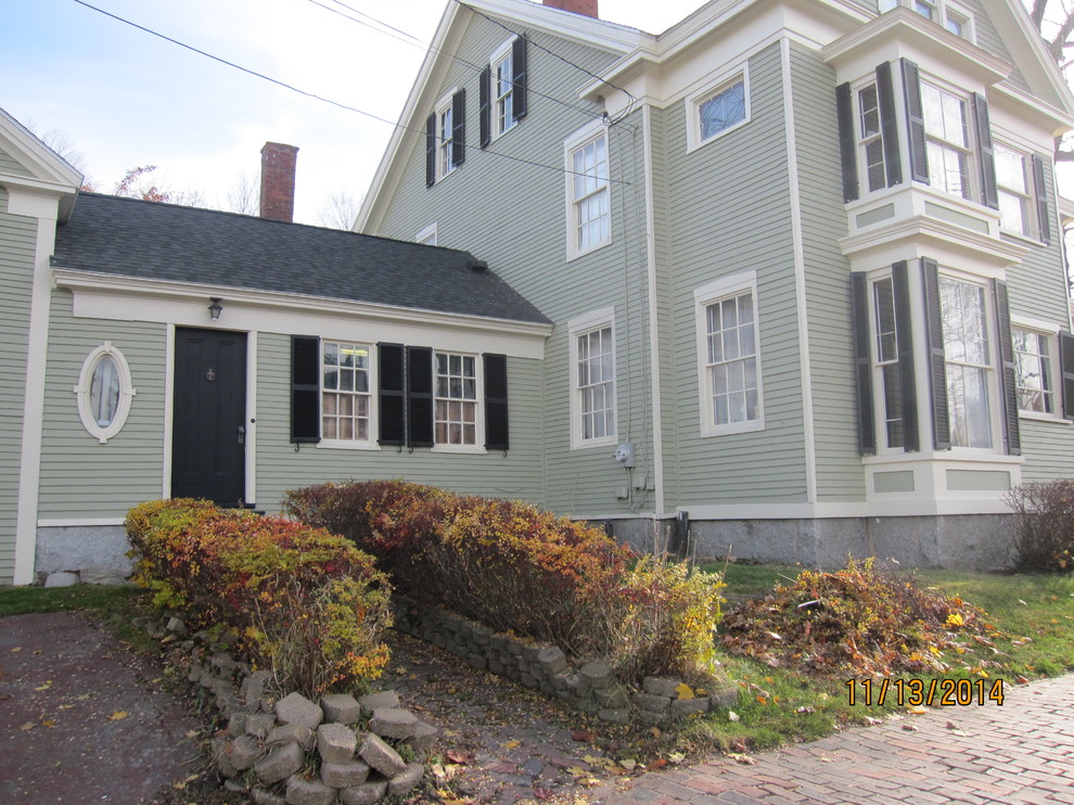 Photo of a large and green rural house exterior in Portland Maine with three floors and wood cladding.