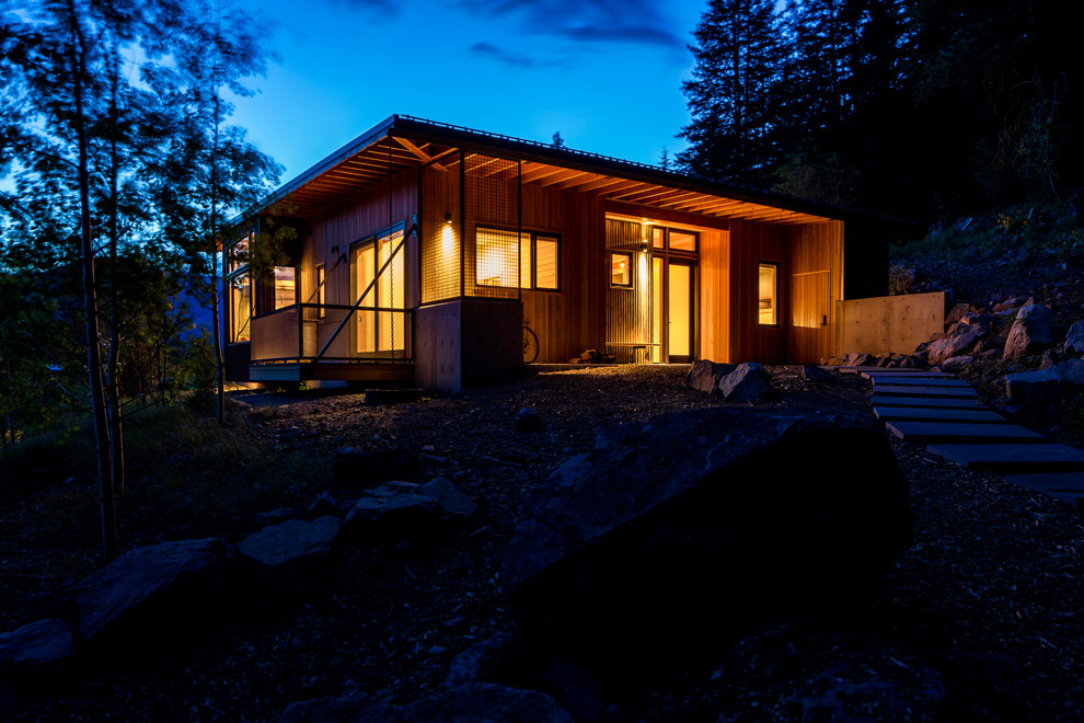 Inspiration for a medium sized and brown rustic bungalow house exterior in Seattle with wood cladding and a flat roof.