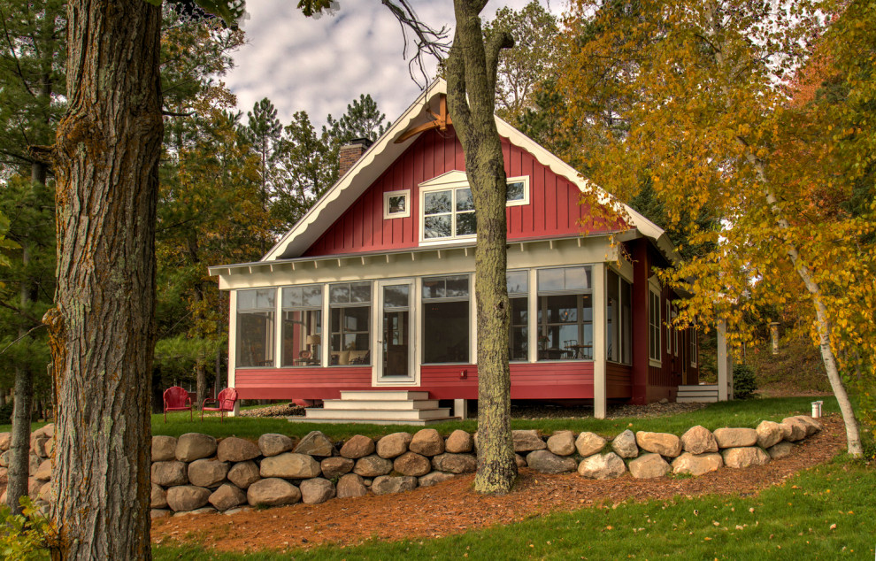 Idée de décoration pour une façade de maison rouge nordique en panneau de béton fibré de taille moyenne et à un étage avec un toit à deux pans et un toit en shingle.