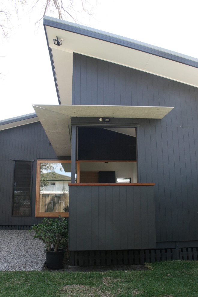 Diseño de fachada de casa gris y gris actual pequeña de una planta con revestimiento de aglomerado de cemento y tejado a cuatro aguas