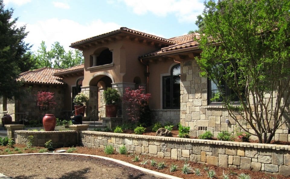 Mid-sized tuscan multicolored one-story stone house exterior photo in Other with a tile roof