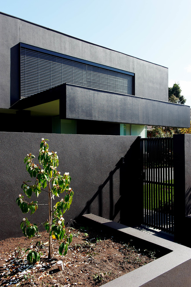 Exemple d'une grande façade de maison noire tendance en béton à un étage.