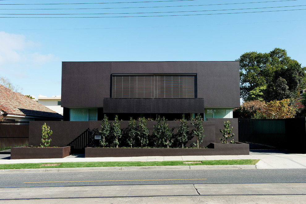 Großes, Zweistöckiges Modernes Haus mit Betonfassade, schwarzer Fassadenfarbe und Flachdach in Melbourne