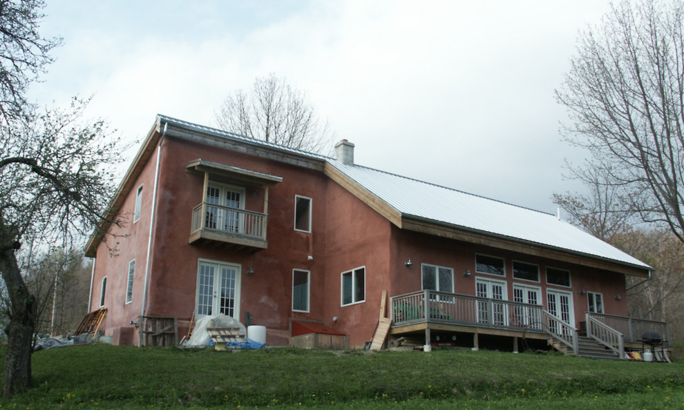 Diseño de fachada de casa roja de tamaño medio de dos plantas con revestimiento de estuco, tejado a dos aguas y tejado de metal