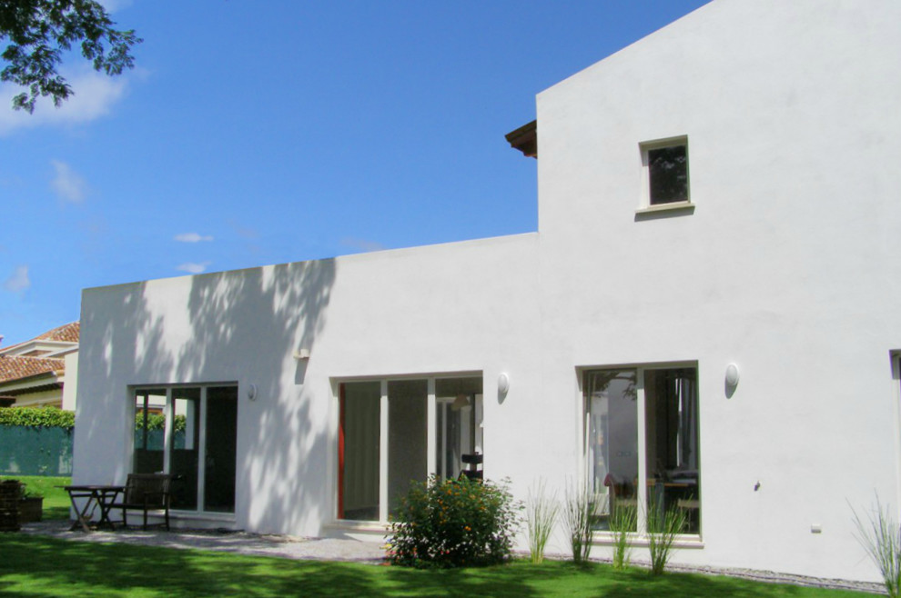 Стильный дизайн: большой, двухэтажный, белый итальянский частный загородный дом в стиле модернизм с облицовкой из цементной штукатурки, двускатной крышей и черепичной крышей - последний тренд