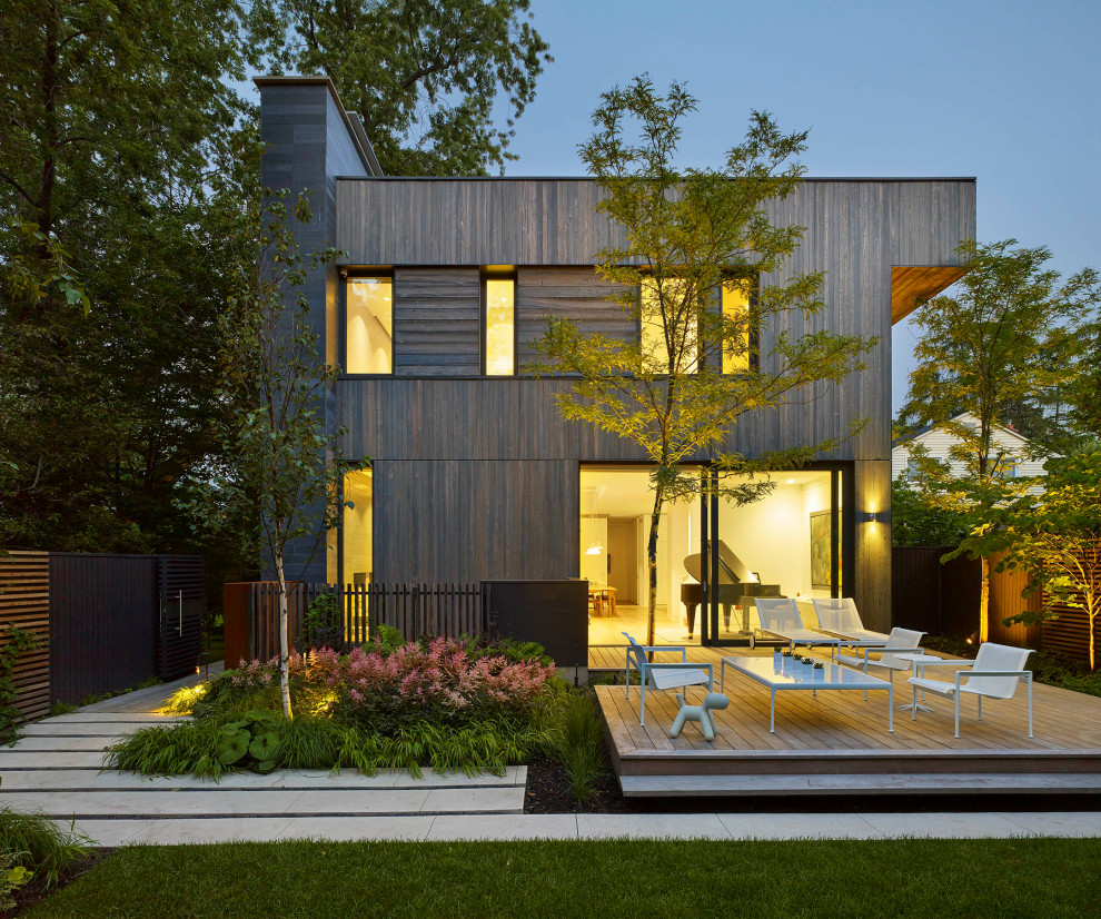 Cette photo montre une façade de maison marron tendance en bois de taille moyenne et à un étage avec un toit plat.