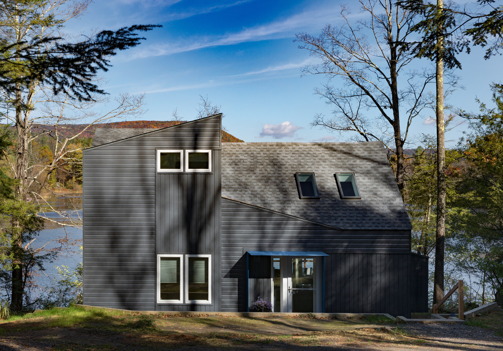 Imagen de fachada de casa gris minimalista grande de dos plantas con revestimiento de aglomerado de cemento y tejado de teja de madera