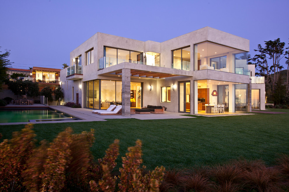 Modelo de fachada de casa gris costera grande de dos plantas con revestimiento de hormigón y tejado plano