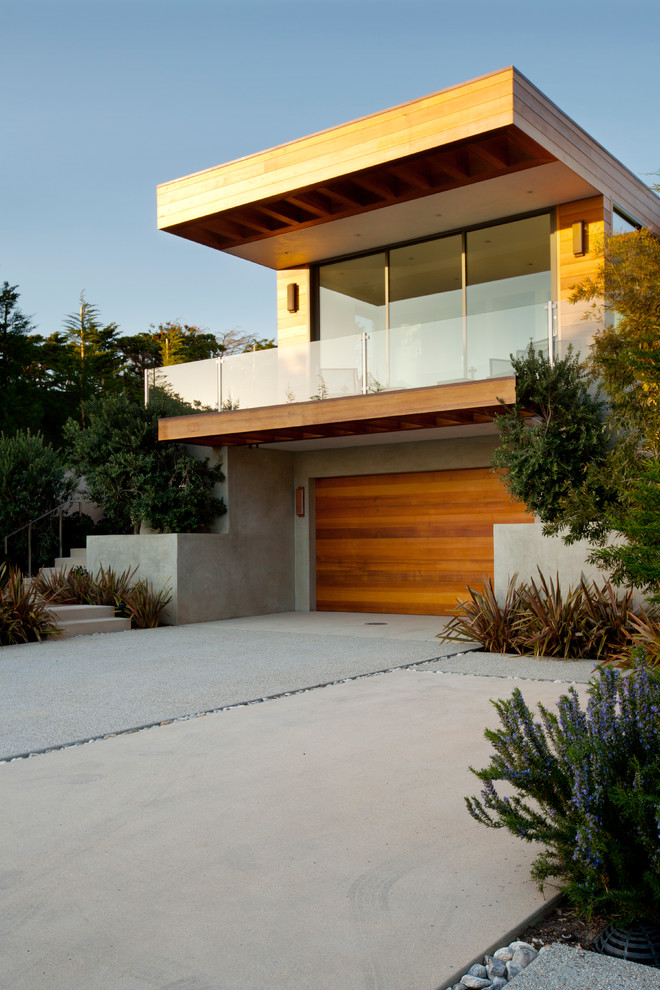 На фото: большой, двухэтажный, серый частный загородный дом в морском стиле с облицовкой из бетона и плоской крышей