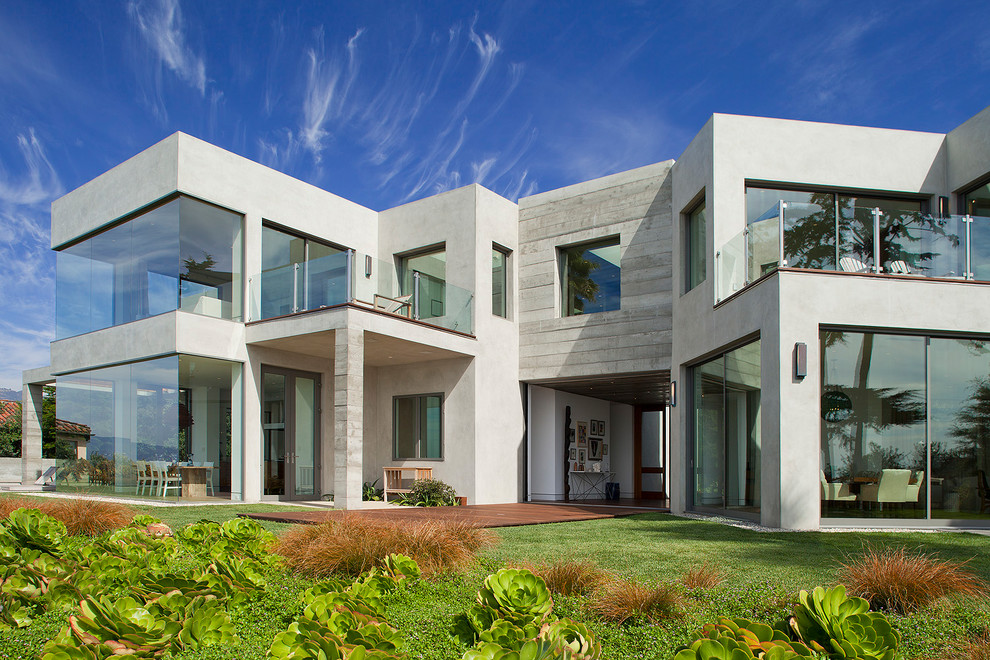 Idée de décoration pour une façade de maison grise marine en béton à un étage avec un toit plat.